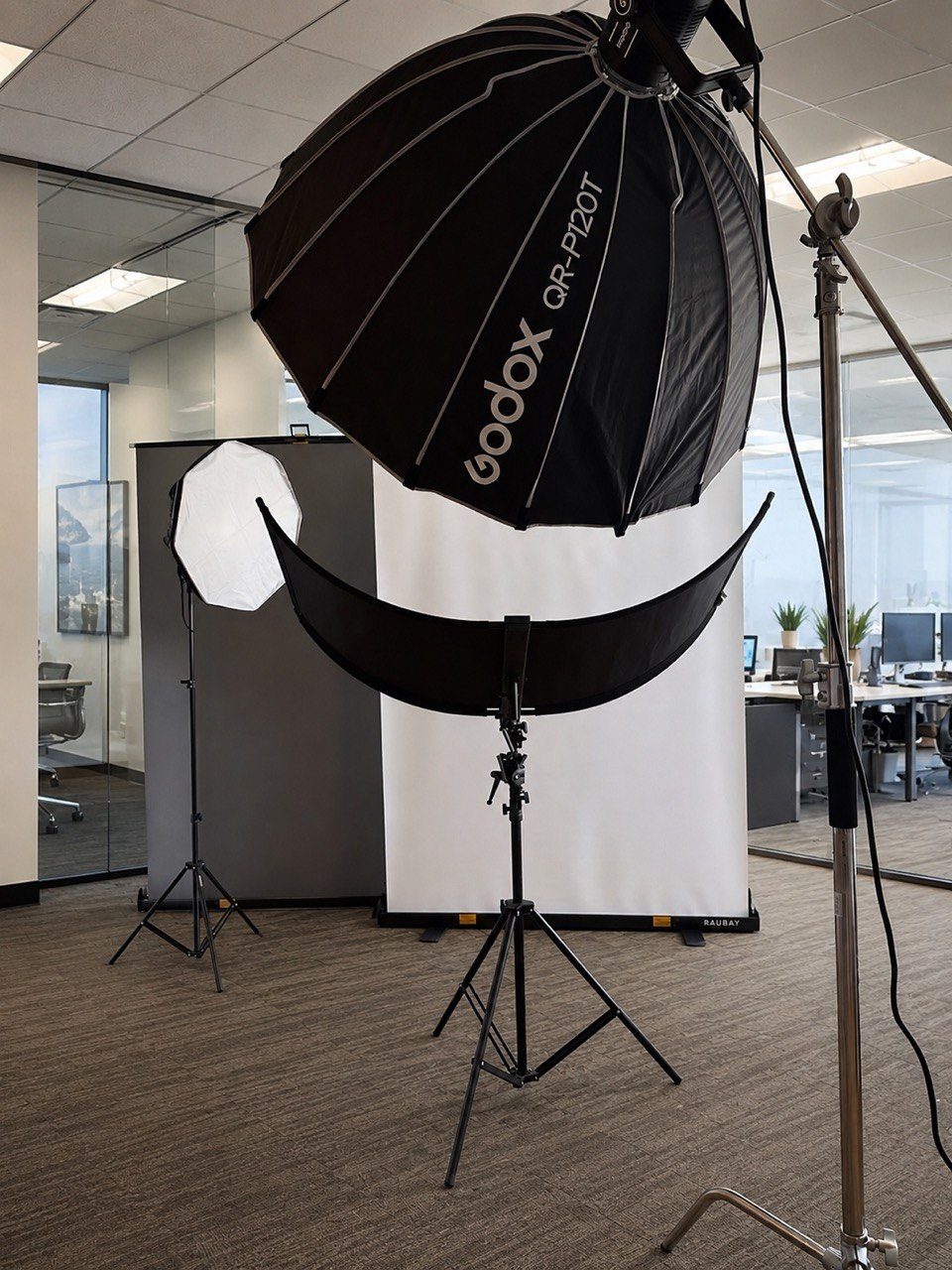 Anna Riazanova's mobile headshot studio — lighting, backdrop and reflector — set up inside a client's office
